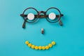 Smile from pills, glasses, blue background. Black Eye Glasses with white pills on blue background Royalty Free Stock Photo