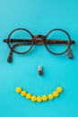 Smile from pills, glasses, blue background. Black Eye Glasses with white pills on blue background Royalty Free Stock Photo