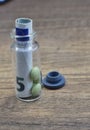 pills in a green shell in a transparent vial