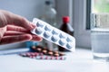 Pills in hand on a background of other different medicines