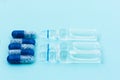 Pills, injection ampoules for vaccination on a blue background, healthcare coronavirus, cancer, painand treatment, pharmaceutical