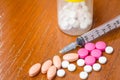 Pills with medicine box and syringe on wood table Royalty Free Stock Photo