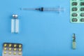 Pills and medicines in blisters on a blue background and syringe copy place Royalty Free Stock Photo