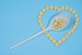 Pills - medicines are poured in the form of heart on a blue background and spoon Royalty Free Stock Photo