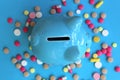 Piggy piggy bank stands on pills on a blue background Royalty Free Stock Photo