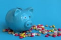 Piggy piggy bank stands on pills on a blue background Royalty Free Stock Photo