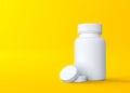 Pills and pill bottle on yellow background with copy space Royalty Free Stock Photo