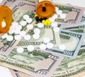 Pills and pill bottles on one hundred and fifty dollar bills Royalty Free Stock Photo