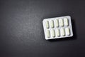 Pills in plastic white packaging on black background Royalty Free Stock Photo