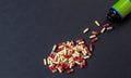 Pills poured out from a jar on a dark background