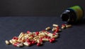 Pills poured out from a jar on a dark background