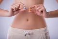 Pills with probiotics on the background of the female abdomen.