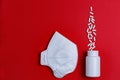 Pills and protective mask on a red background