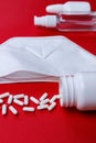 Pills and protective mask on a red background