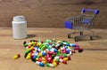 Pills at a shopping basket on wood backgrond. Economy concept of spending money on medicines and pills. Medical pill for