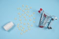 Pills in shopping cart on blue background. The concept: trade in medicines, pharmacies Royalty Free Stock Photo