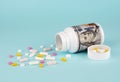 Pills spilling out of pill bottle on blue background with copy space. Royalty Free Stock Photo