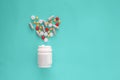 Pills spilling out of pill bottle and isolated on green background Royalty Free Stock Photo