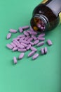 Pills spilling out of pill bottle and isolated on green. Top view with copy space Royalty Free Stock Photo