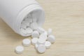 Pills spilling out of pill bottle on wood back ground Royalty Free Stock Photo