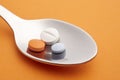 Pills and spoon detail. Orange background. Medicament treatment.