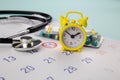 Pills, stethoscope, alarm clock and calendar on a table, schedule to check up healthy concept Royalty Free Stock Photo