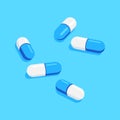 Pills and tablets of medical drugs on blue background.