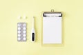 Pills, thermometer and note for recipe on yellow background. Cold and flu treatment set. Flat lay, top view. Royalty Free Stock Photo