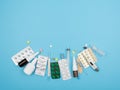 Pills, thermometers, syringe and nasal sprays for treatment on a blue background