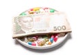 Pills and Ukrainian money on a white background. Royalty Free Stock Photo