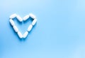 Pills of vitamin in the shape of heart on soft blue background Royalty Free Stock Photo