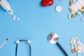 Pills, vitamins and disposable syringe, heart, stethoscope on blue background top view see doctor Royalty Free Stock Photo