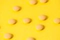 Pills or vitamins on a yellow background with place for text. Pharmacology and medecine concept