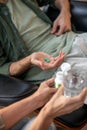 Close up of psychoanalyst giving pills and water to her client