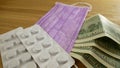 Pills in white plastic, medical masks and dollars on the table. Royalty Free Stock Photo