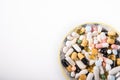 Pills on a white plate. A pile of multi-colored tablets disguised as food on a plate with cutlery. Medicines on a white plate Royalty Free Stock Photo