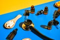 Pills on wooden spoon and dropper pipette on blue and yellow background. Hard light and shadows. Modern isometric creative