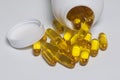 Pills of yellow color are poured on a white surface from plastic jar. Royalty Free Stock Photo