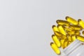 Pills of yellow color are poured on a white surface from plastic jars.