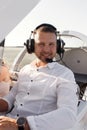 A man is sitting in the cockpit of his private plane. The pilot, against the background of the plane at sunset. Royalty Free Stock Photo