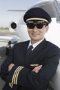 Pilot With Arms Folded Leaning On Airplane Royalty Free Stock Photo