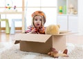 Pilot aviator baby with teddy bear toy and planes plays in cardboard box Royalty Free Stock Photo