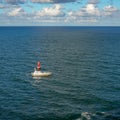 A pilot boat escorts a cruise ship into or out of port from the ocean channel