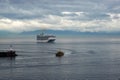 A pilot boat escorts a cruise ship into or out of port from the ocean channel