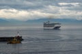 A pilot boat escorts a cruise ship into or out of port from the ocean channel