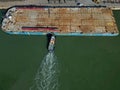 Pilot boat pushing flat top barge at Southampton Docks UK aerial