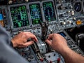 Pilot controlling airplane throttle levers in cockpit during flight Royalty Free Stock Photo