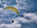 A pilot flies a yellow paramotor above Benone Strand Beach on the Atlantic Coast of Northern Ireland.