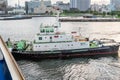 A pilot ship Tug ship in is pushing our a large cruise ship in Yokohama Japan