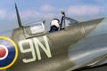 Pilot sits in cockpit of Supermarine Spitfire british fighter aircraft